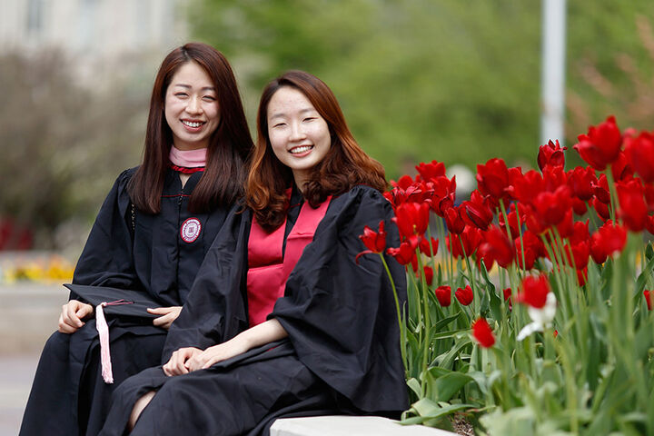 Two smiling students in graduation caps and gowns